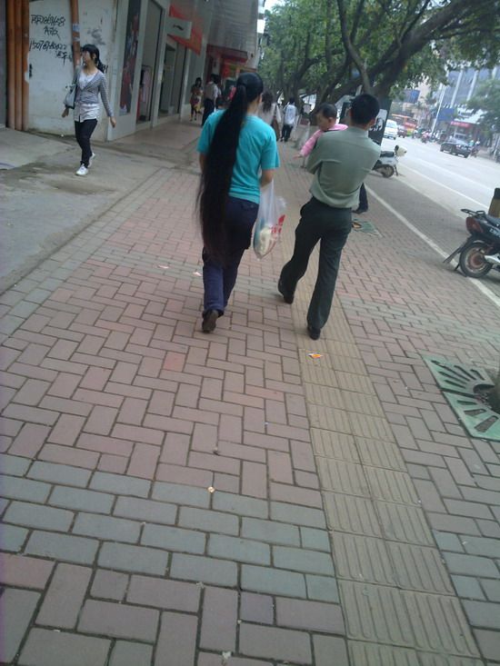 Streetshot of long ponytail by mobilephone in Labour Day