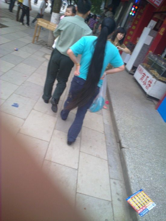 Streetshot of long ponytail by mobilephone in Labour Day