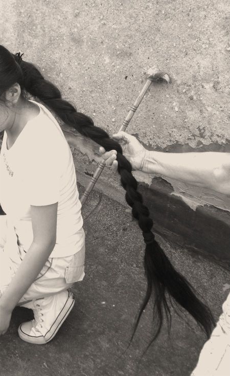 And old woman held young girl's long braid