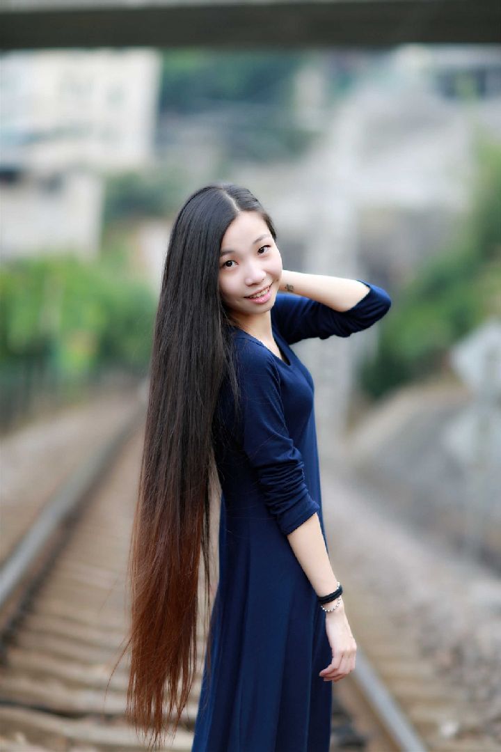 Beautiful girl show long hair on railway